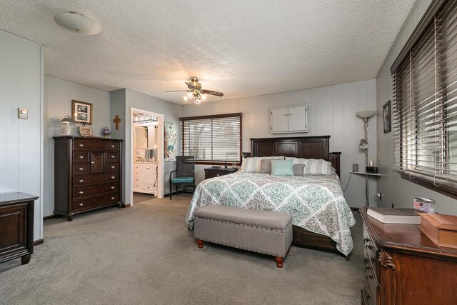 bedroom featuring ceiling fan, multiple windows, ensuite bathroom, and light colored carpet