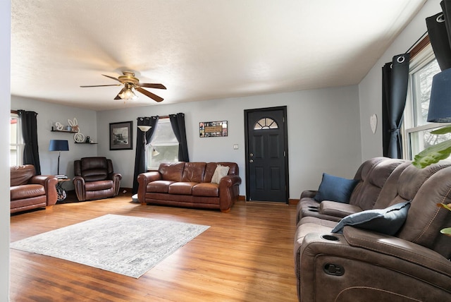 living area with a ceiling fan and light wood finished floors