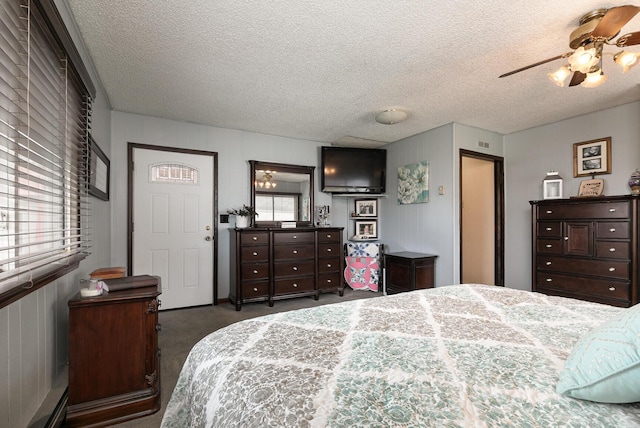 carpeted bedroom with a textured ceiling, visible vents, and a ceiling fan