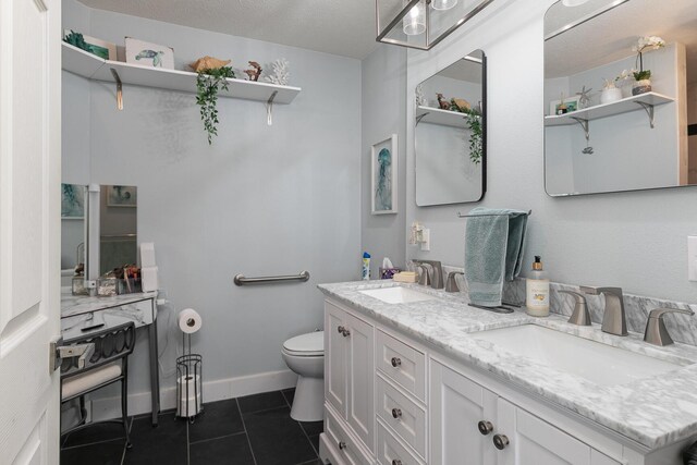 full bath featuring toilet, tile patterned flooring, double vanity, and a sink