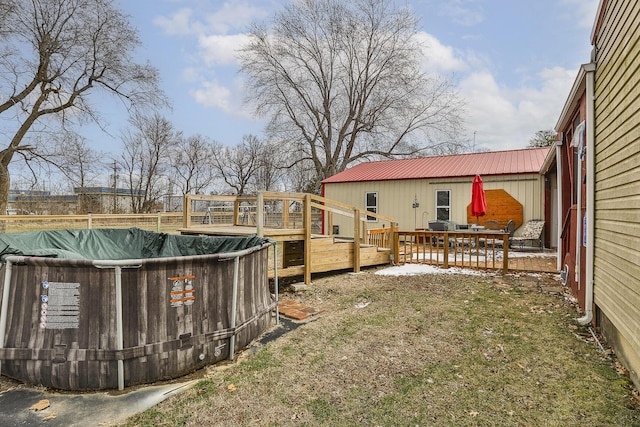 view of yard with a wooden deck and a covered pool