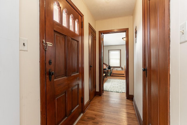 hall with wood finished floors and baseboards