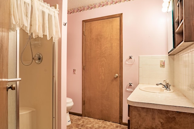 full bath with a stall shower, vanity, toilet, and backsplash