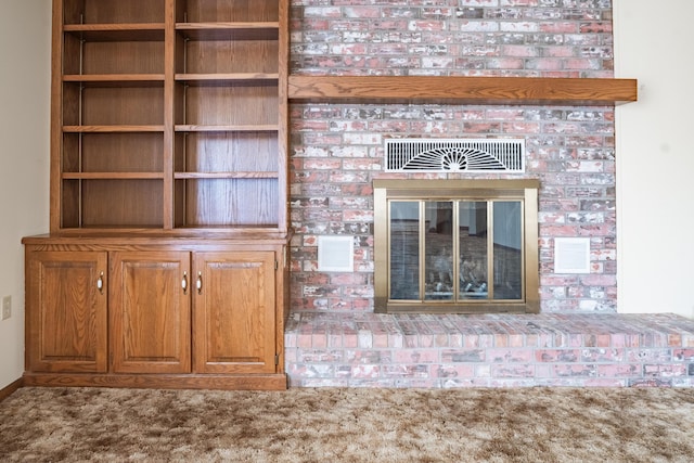 interior details with a brick fireplace and carpet