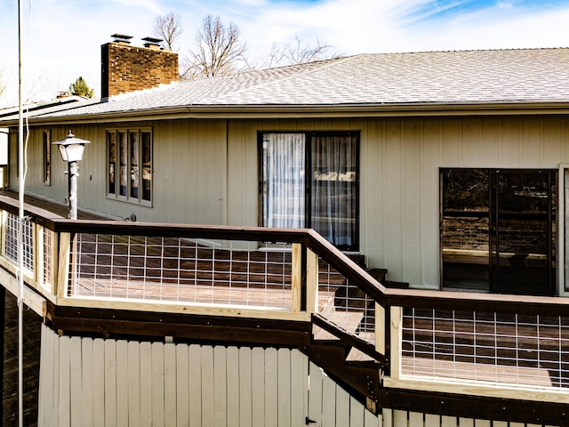 back of property featuring a shingled roof and a chimney