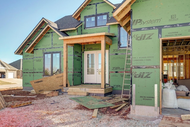 exterior space with french doors and a shingled roof