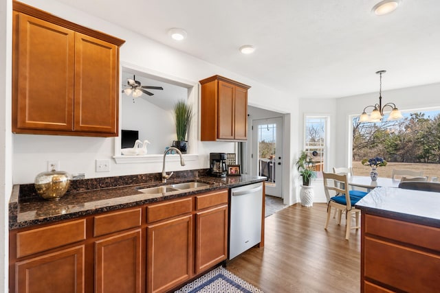 kitchen featuring dishwasher, dark wood-style floors, a healthy amount of sunlight, and a sink