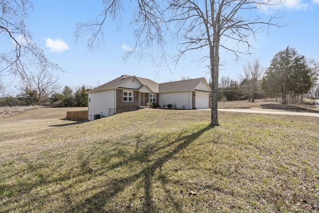 view of front of home with a front yard, an attached garage, and brick siding