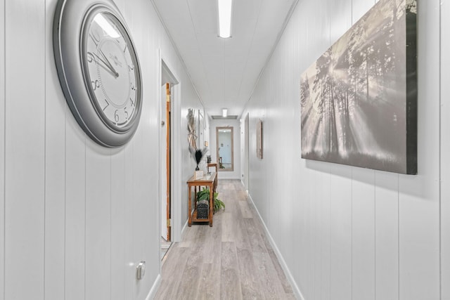 hallway featuring wood finished floors and baseboards