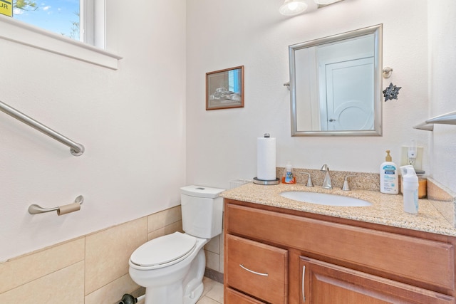 half bathroom with tile patterned flooring, vanity, and toilet