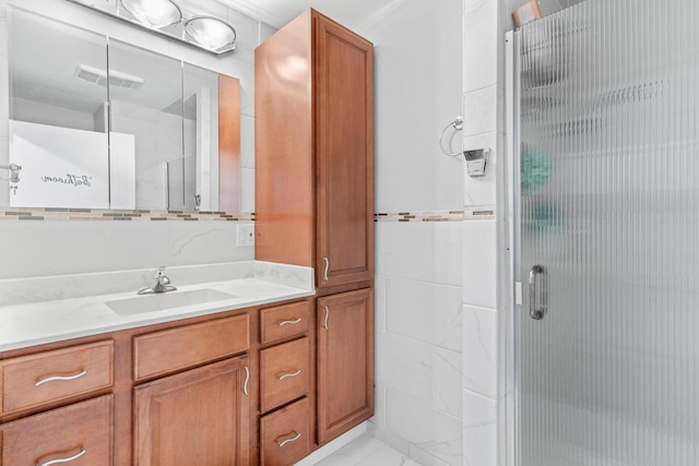 bathroom with visible vents, vanity, tile walls, marble finish floor, and a shower stall