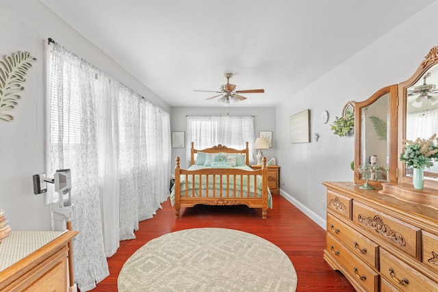 bedroom with dark wood-style floors, ceiling fan, and baseboards