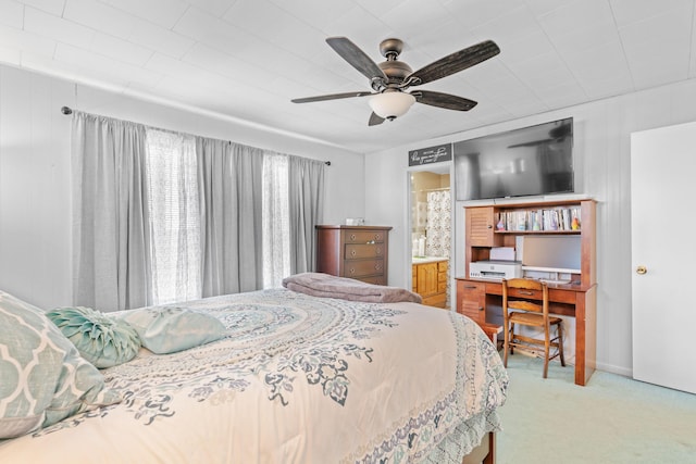 bedroom with ceiling fan, connected bathroom, and light colored carpet