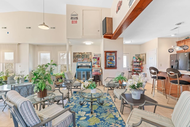 living area featuring light tile patterned floors, visible vents, and a healthy amount of sunlight