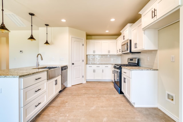 kitchen with light stone counters, stainless steel appliances, decorative backsplash, white cabinets, and a sink