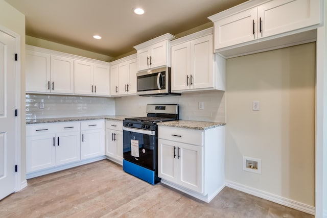 kitchen featuring light stone counters, stainless steel appliances, recessed lighting, backsplash, and white cabinets