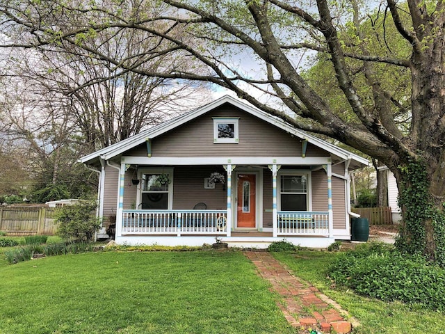 bungalow featuring fence, a porch, and a front yard