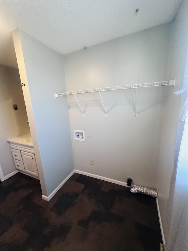 laundry room with hookup for a washing machine, laundry area, a textured ceiling, and baseboards