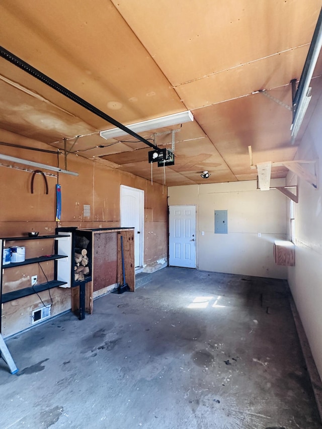 garage with electric panel and a garage door opener