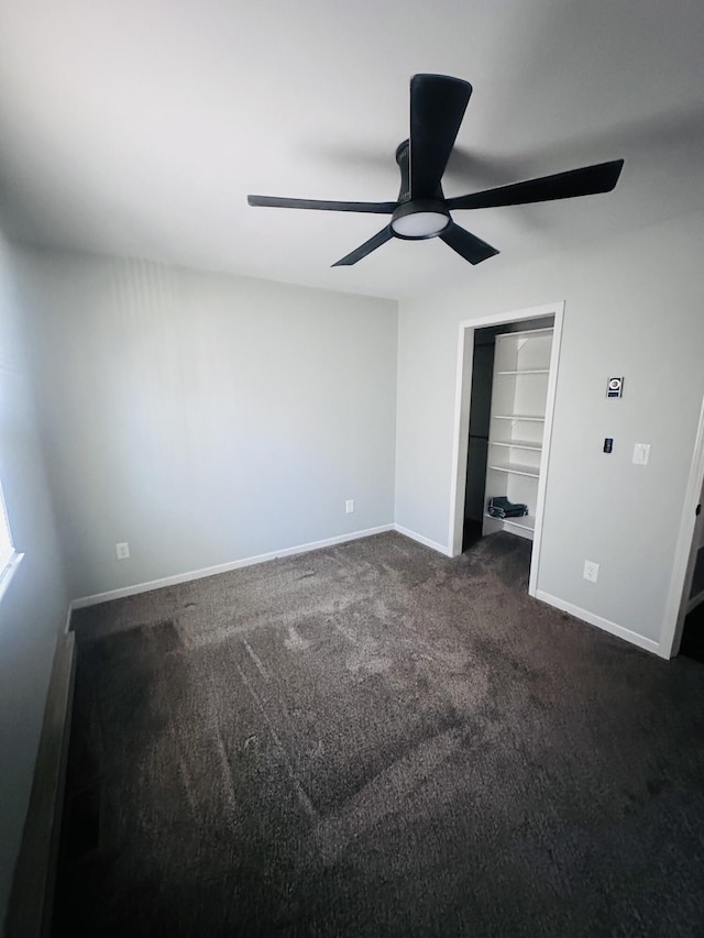 unfurnished bedroom with a ceiling fan, baseboards, dark carpet, and a closet