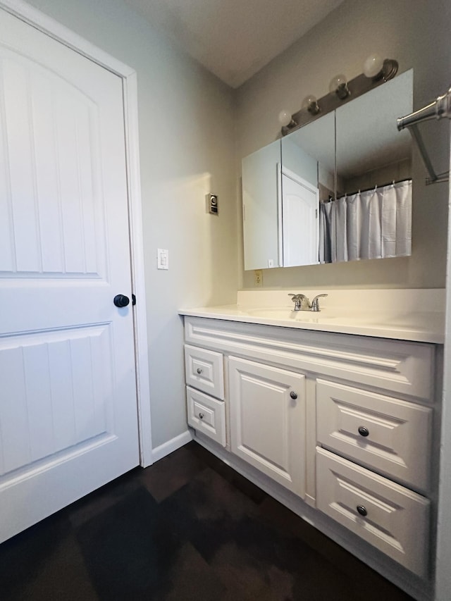 full bath featuring vanity and baseboards