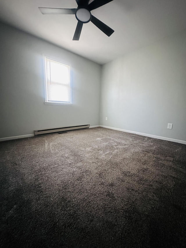 spare room featuring a baseboard heating unit, carpet, baseboards, and a ceiling fan