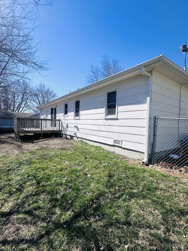 view of property exterior with a lawn and a wooden deck