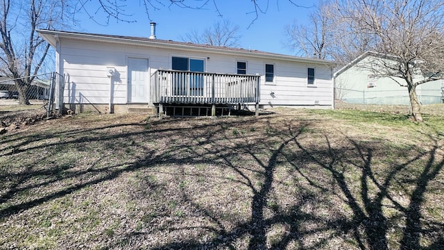 rear view of property featuring fence and a deck