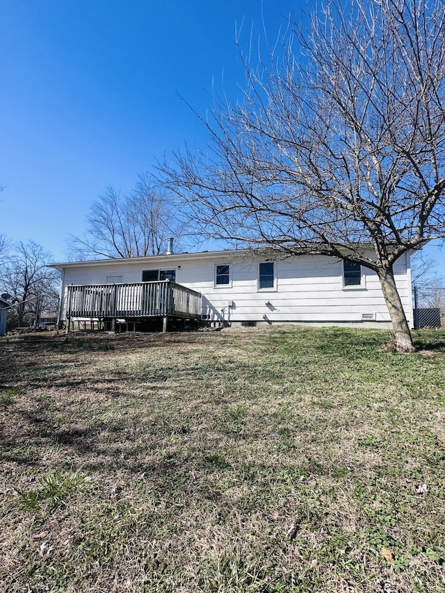 back of house featuring a yard and a wooden deck