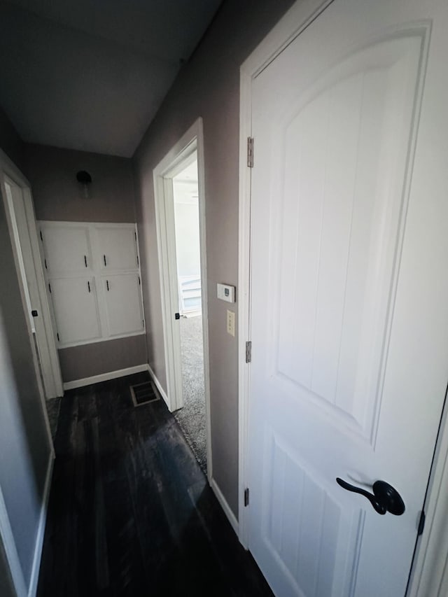 hall with dark wood-style floors and baseboards