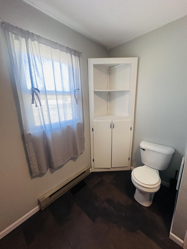 bathroom featuring a baseboard radiator, baseboards, a textured ceiling, and toilet