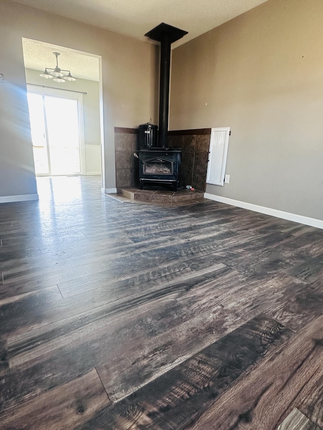 living area featuring a wood stove, dark wood-style floors, and baseboards