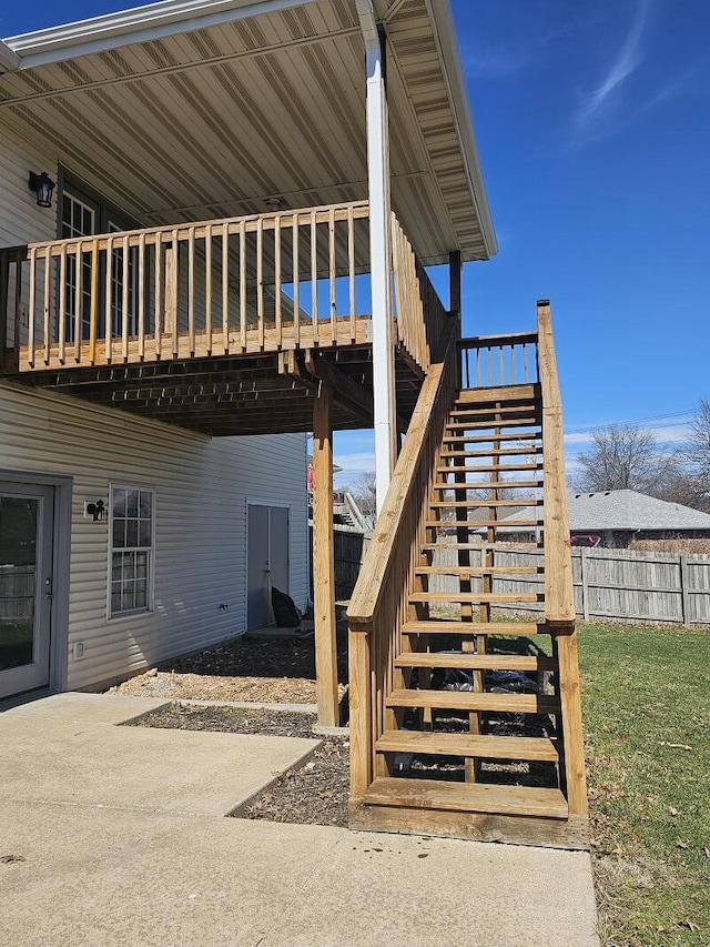 view of patio with a deck, fence, and stairway