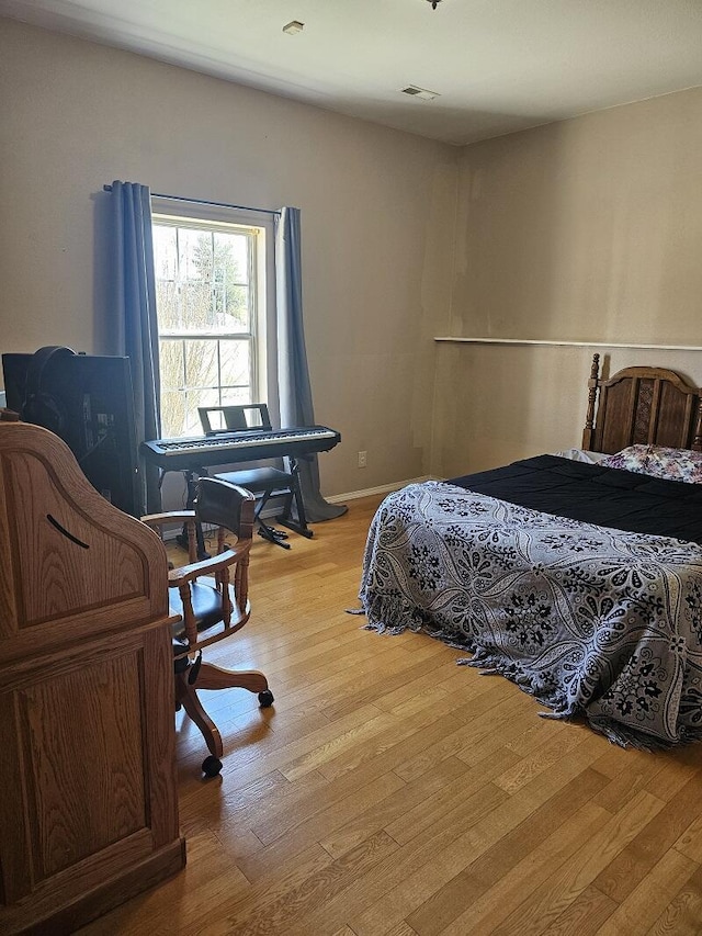 bedroom with light wood-type flooring and visible vents