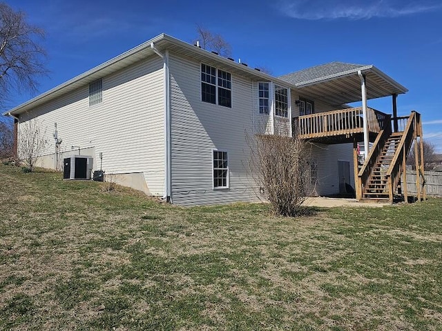 back of house featuring stairs, central AC unit, a deck, and a yard