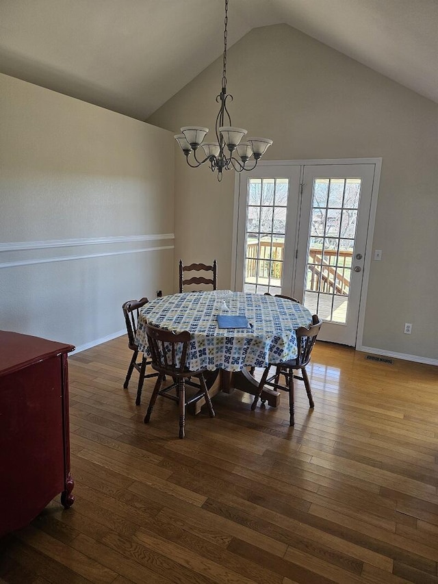 dining room featuring baseboards, a notable chandelier, visible vents, and wood finished floors