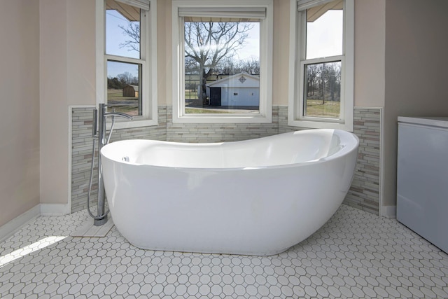 bathroom with a soaking tub, tile walls, and tile patterned floors