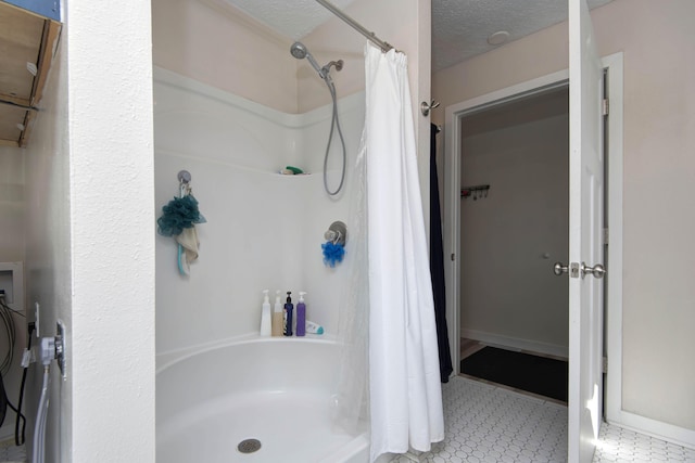 bathroom with a shower with curtain and a textured ceiling