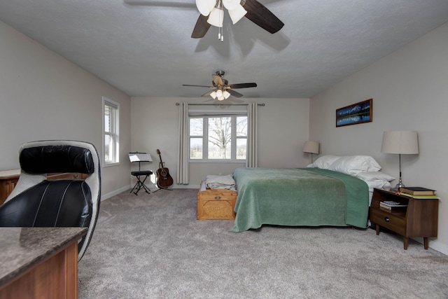 bedroom featuring light carpet, ceiling fan, a textured ceiling, and baseboards