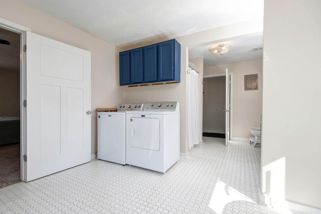 clothes washing area with washer and dryer, baseboards, and light floors