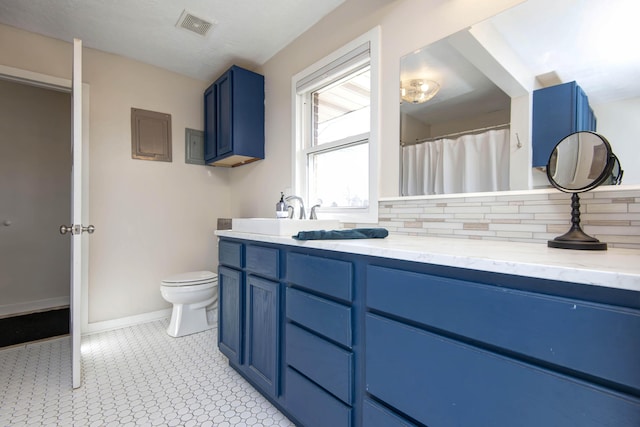 full bathroom with baseboards, visible vents, decorative backsplash, toilet, and vanity