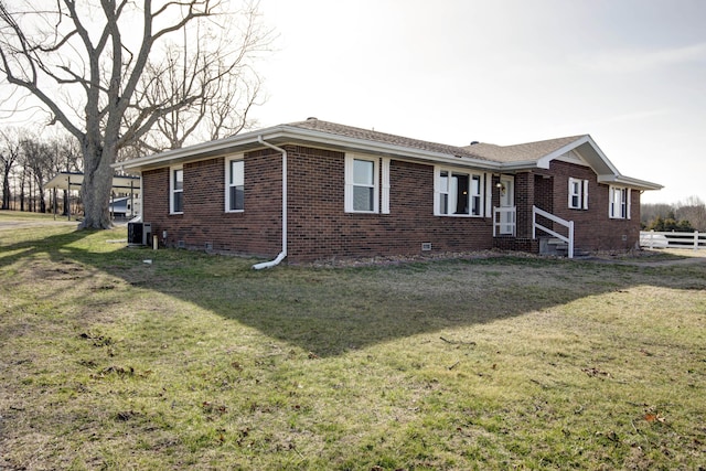 ranch-style home with fence, central AC unit, a front lawn, and brick siding