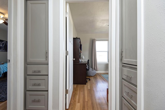 corridor featuring wood finished floors and baseboards