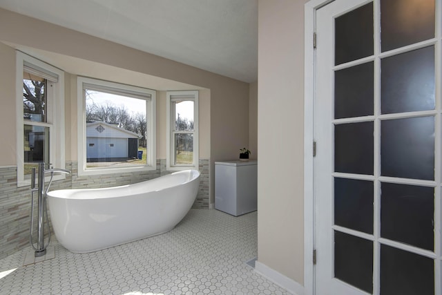 full bath with a freestanding tub and tile walls