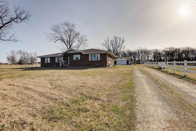 view of front of property with a garage, brick siding, a front yard, and fence