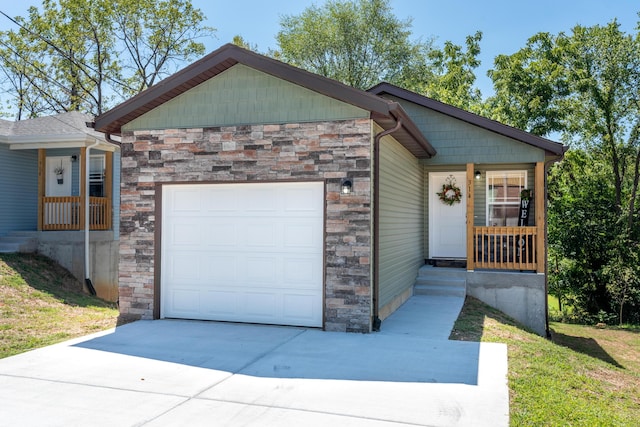 view of front of property featuring a garage, stone siding, and concrete driveway