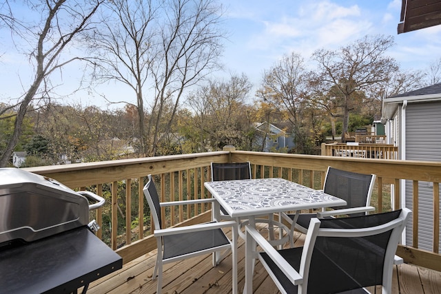 wooden deck featuring area for grilling and outdoor dining space