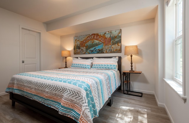 bedroom featuring wood finished floors and baseboards