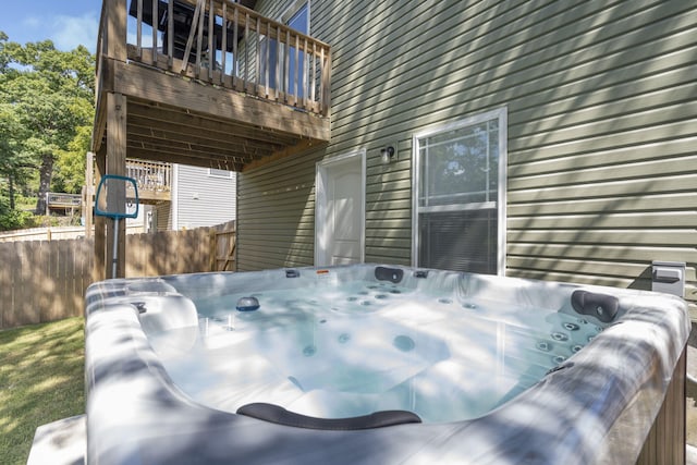 deck featuring fence and a hot tub