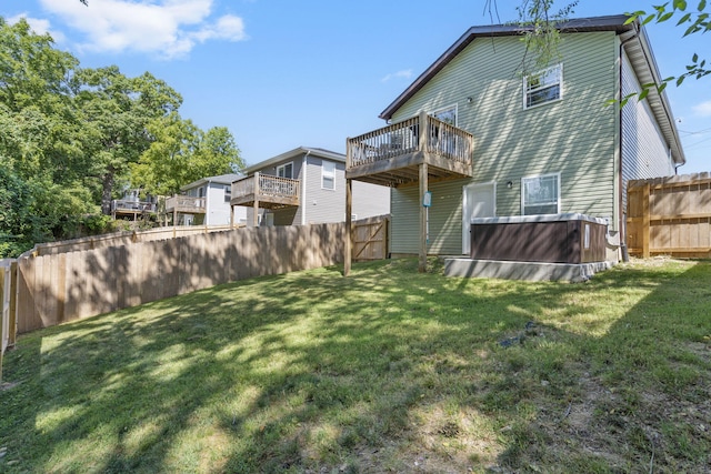 rear view of house featuring a fenced backyard and a lawn